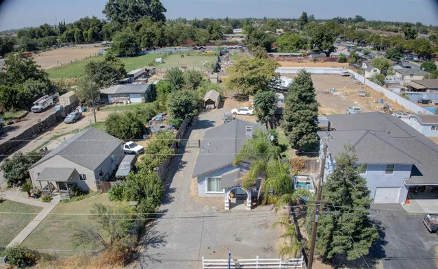 an aerial view of residential houses with outdoor space and parking