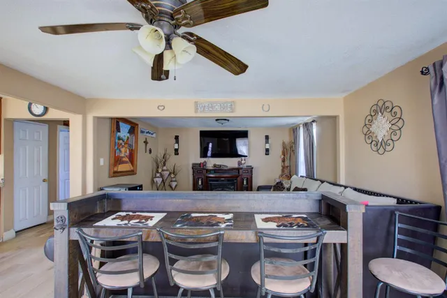 a kitchen with stainless steel appliances kitchen island granite countertop a table chairs in it and wooden floors