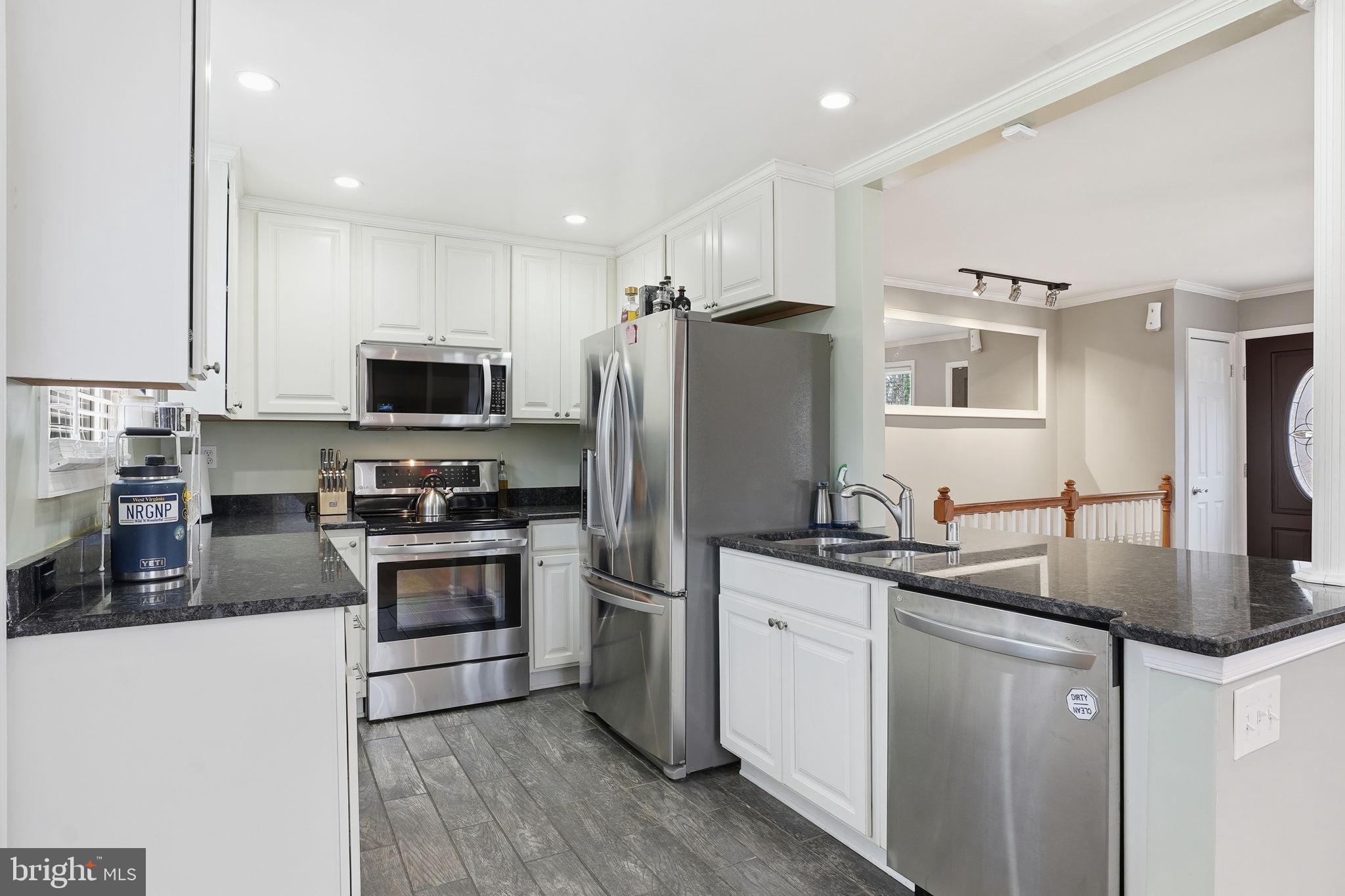 16402 Baden Naylor Road Brandywine, MD 20613 - Photo 12 of 37 a kitchen with granite countertop a sink stainless steel appliances and white cabinets