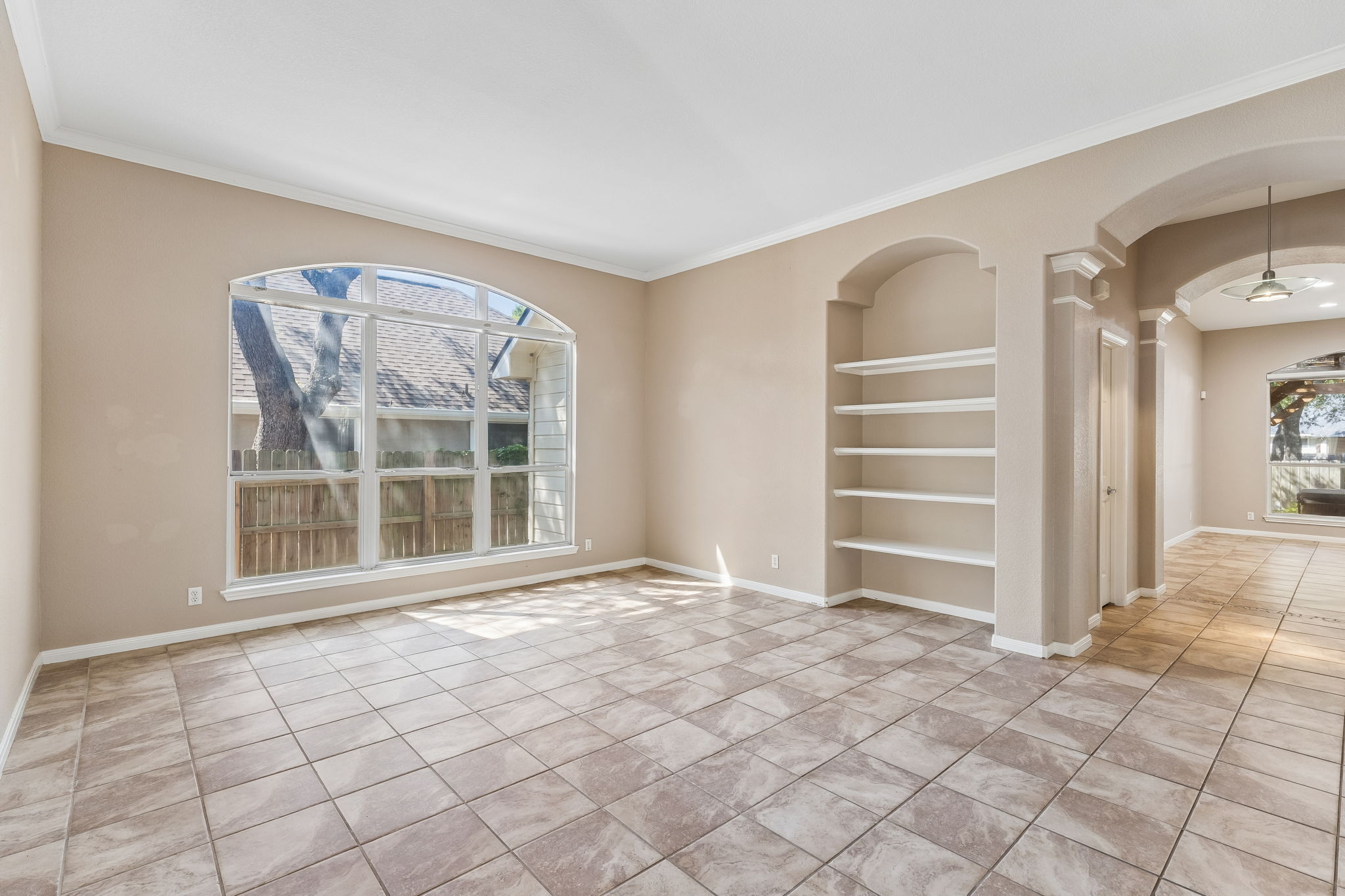 15814 Rustic Lane Austin, TX 78717 - Photo 12 of 29 Tiled flooring and arched architectural details frame this open living space with built-in shelving.