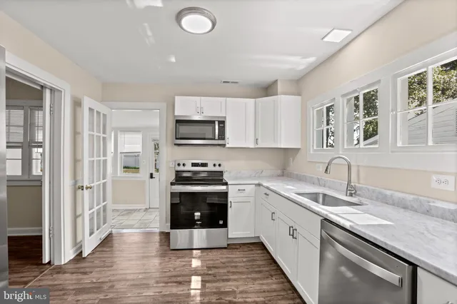 a large kitchen with stainless steel appliances granite countertop a sink and cabinets