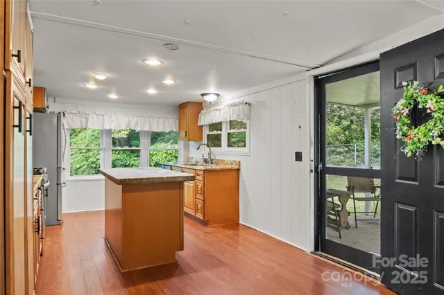 a kitchen with kitchen island a sink and a large window