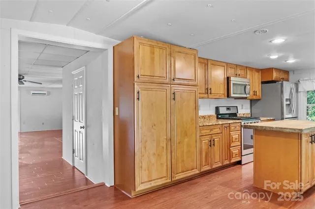 a kitchen with stainless steel appliances granite countertop a refrigerator and a stove top oven