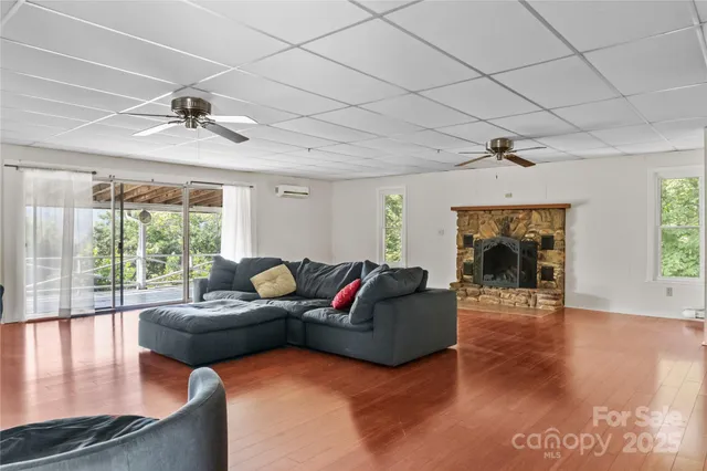 a living room with fireplace furniture and a large window