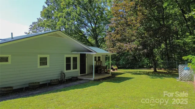 a view of a house with backyard and a tree