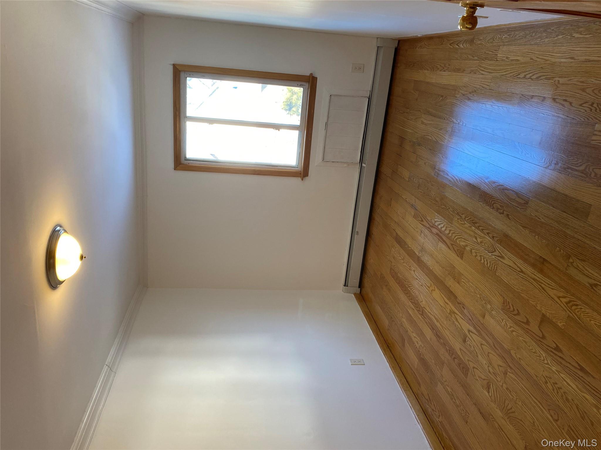 145-41 Willets Point Boulevard Queens, NY 11357 - Photo 5 of 8 an empty room with wooden floor and windows