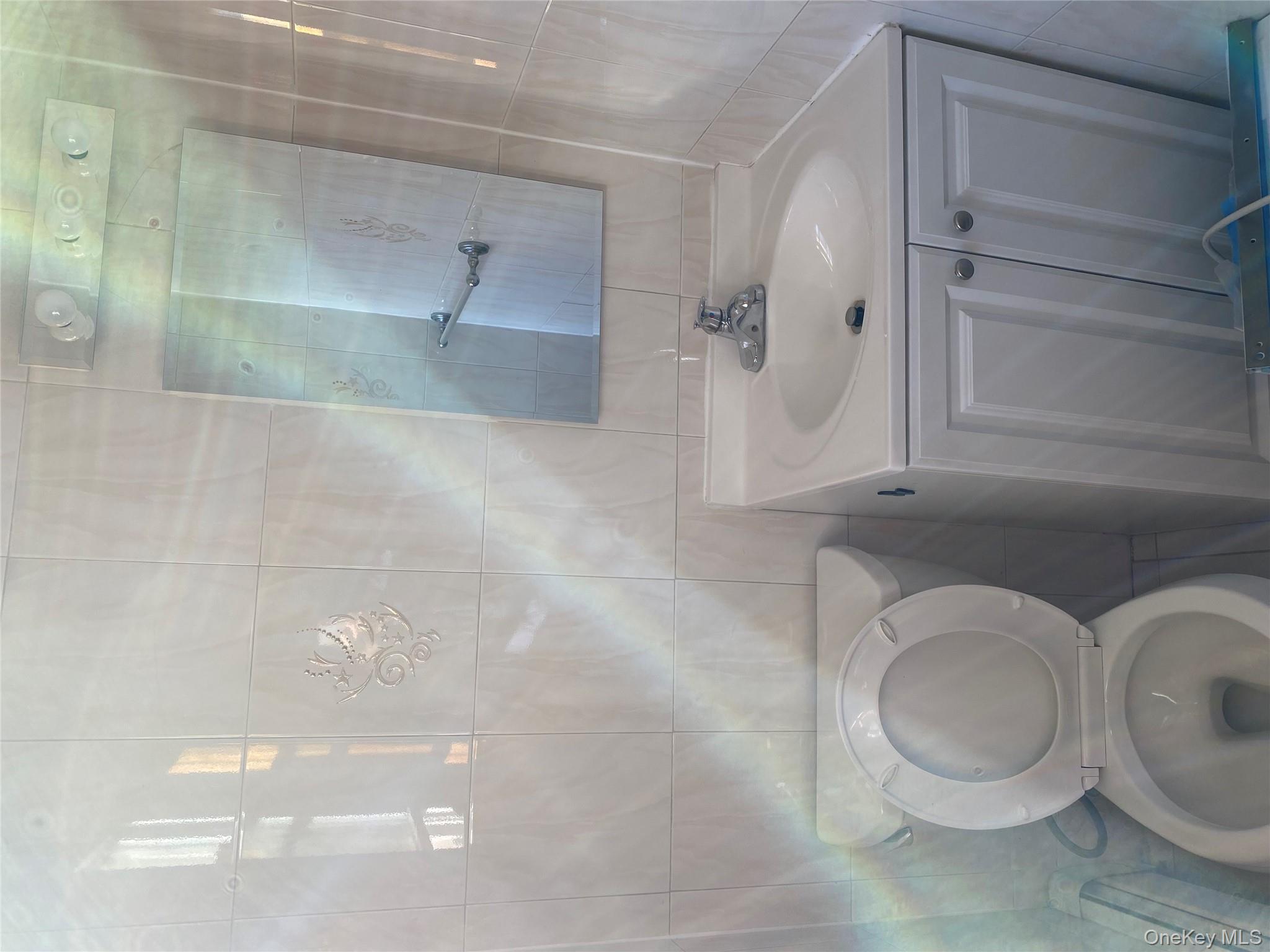 145-41 Willets Point Boulevard Queens, NY 11357 - Photo 7 of 8 a bathroom with a toilet sink and mirror