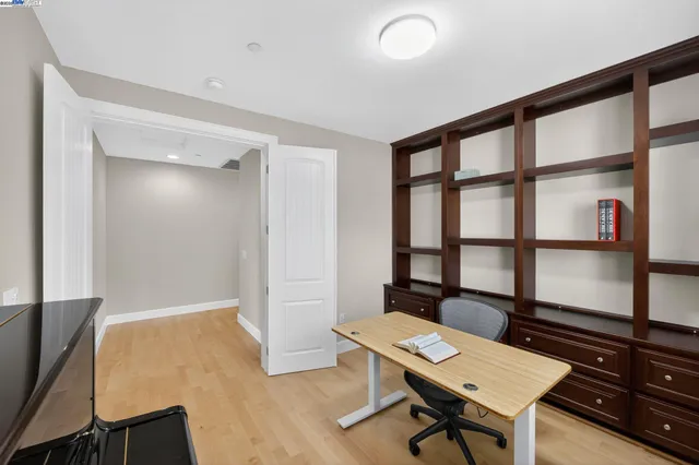a view of a workspace with furniture and a window