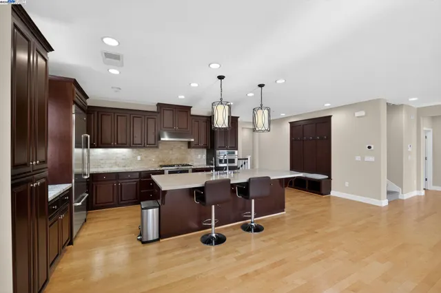 a kitchen with stainless steel appliances granite countertop a sink stove and refrigerator
