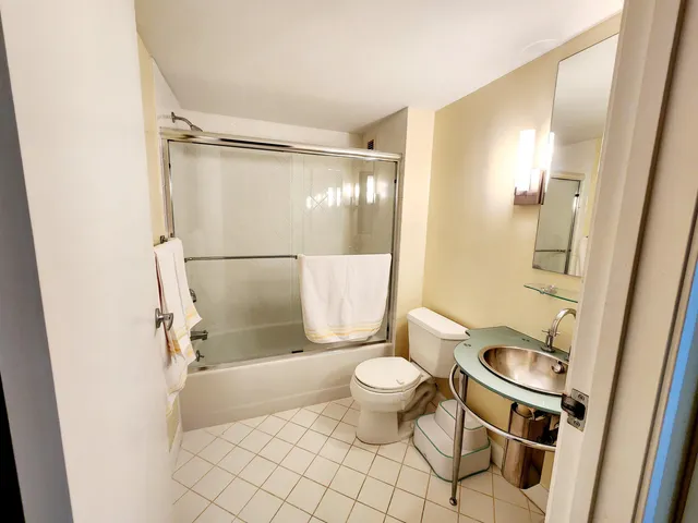 a bathroom with a granite countertop sink toilet and shower