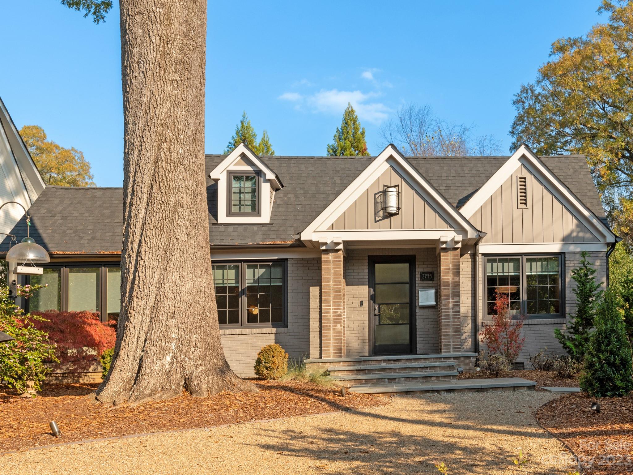 a view of a brick house with many windows and a yard