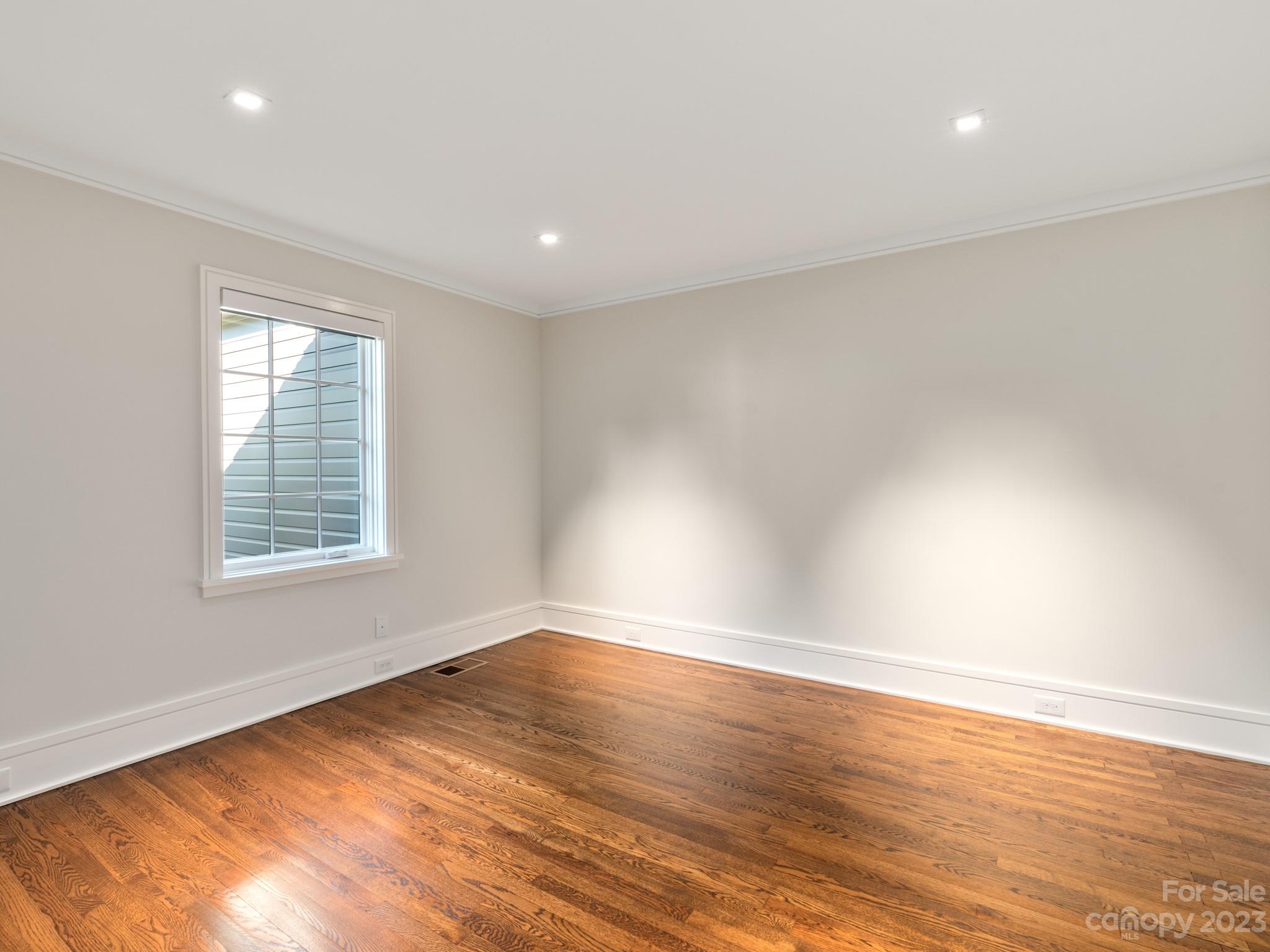 2743 Normandy Road Charlotte, NC 28209 - Photo 19 of 43 an empty room with wooden floor and windows