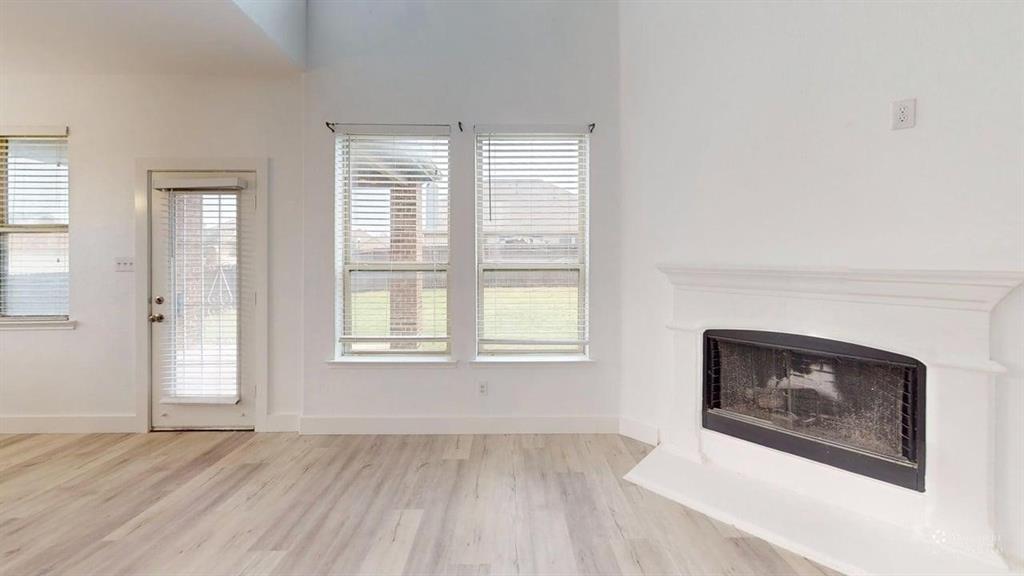 101 Rocky Pine Road McKinney, TX 75072 - Photo 16 of 39 an empty room with windows and a fireplace