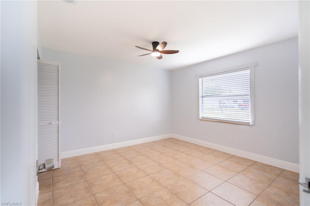1940 48th Street Southwest Naples, FL 34116 - Photo 26 of 33 Spacious room featuring tile flooring, a ceiling fan, window with blinds, and louvered closet doors