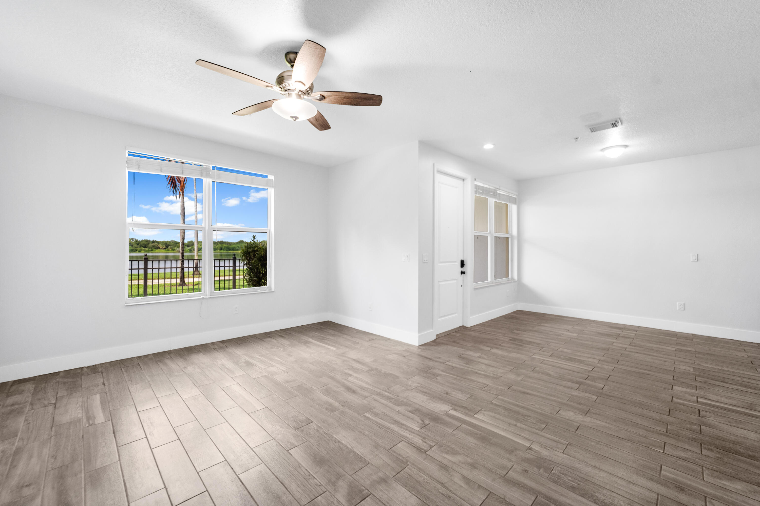 1430 Northwest 48th Lane Boca Raton, FL 33431 - Photo 9 of 54 a view of an empty room with a window and wooden floor