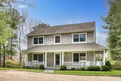 a front view of a house with a yard and trees