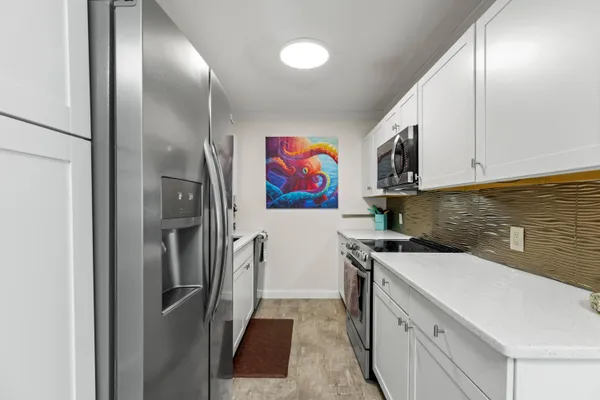 a kitchen with stainless steel appliances granite countertop a sink a stove and a refrigerator