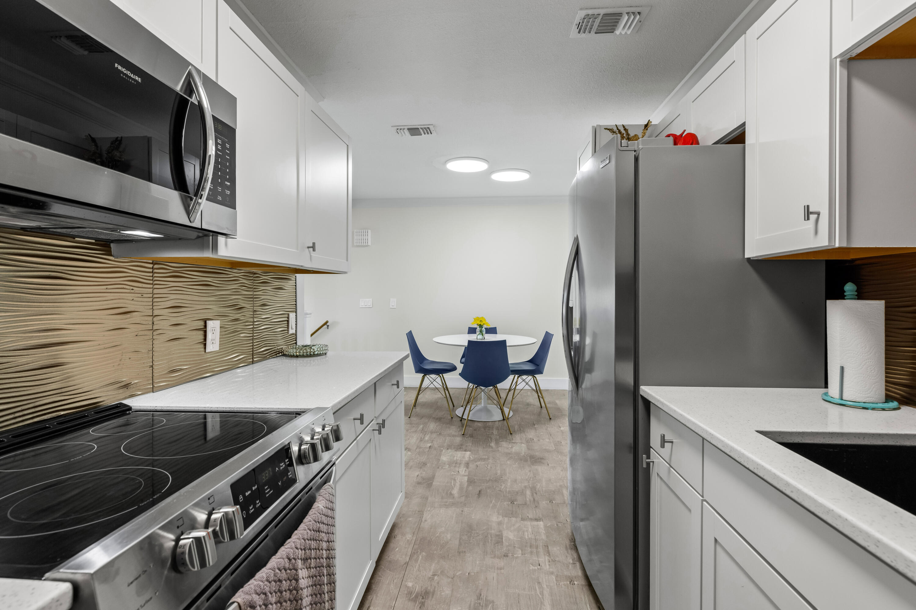 22 Moreno Point Road, Unit 3 Destin, FL 32541 - Photo 21 of 43 a kitchen with stainless steel appliances granite countertop a sink a stove and a refrigerator