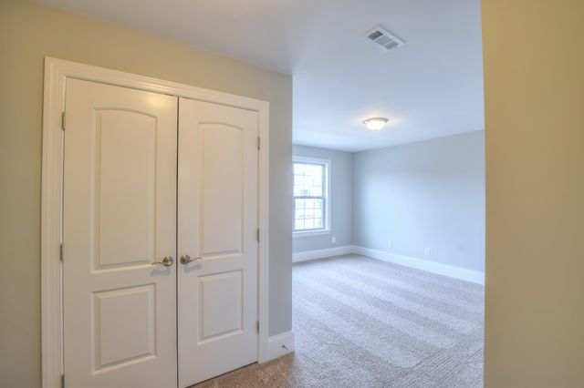 a view of hallway with window and wooden floor
