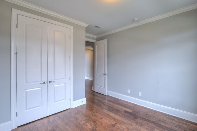 a view of an empty room with a chandelier fan