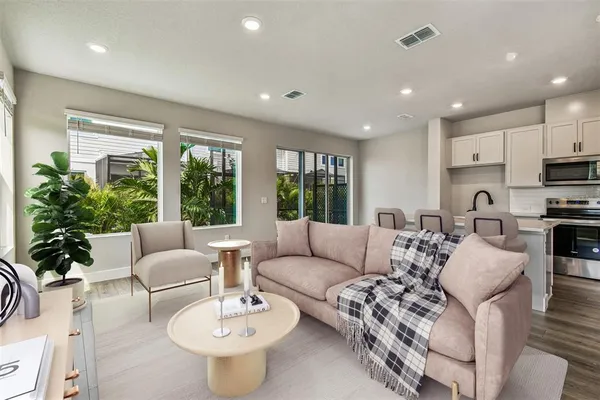 a large kitchen with a lot of white cabinets and wooden floor
