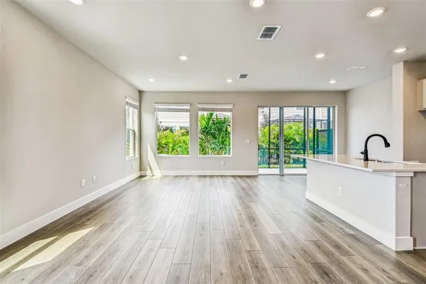 a view of kitchen with kitchen island wooden floor center island and stainless steel appliances