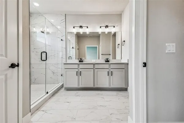 a bathroom with a double vanity sink mirror and shower