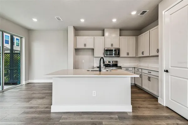 a kitchen with white cabinets and stainless steel appliances