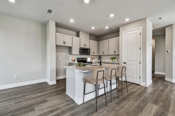 a kitchen with a sink cabinets and wooden floor