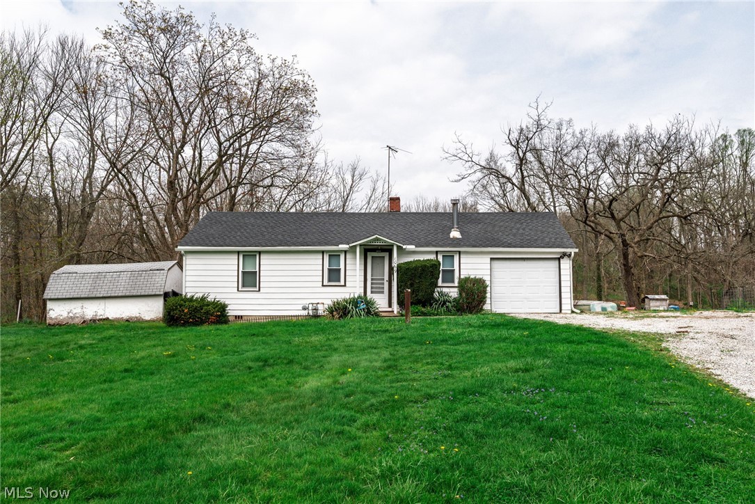 1069 West Nimisila Road New Franklin, OH 44216 - Photo 1 of 26 The property features a ranch-style house with white siding, a dark roof, and an attached garage