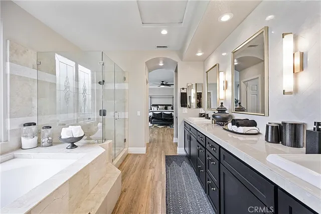 a large bathroom with a double vanity sink a toilet a mirror and shower