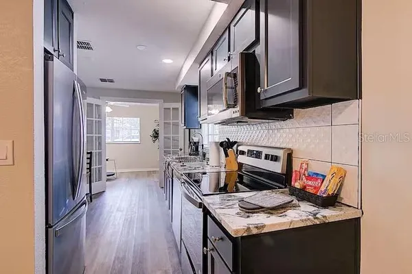 a kitchen with stainless steel appliances granite countertop a stove refrigerator and a microwave oven
