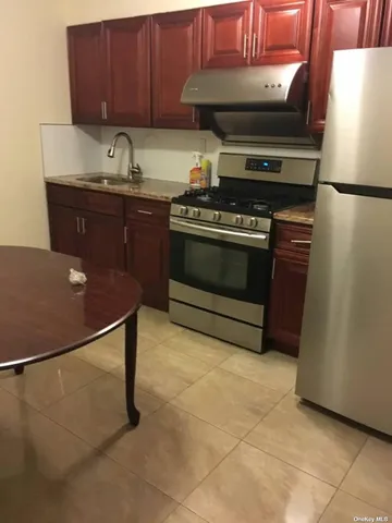 a kitchen with granite countertop a stove a sink and a refrigerator