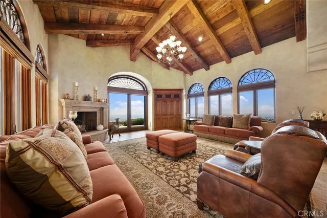 a living room with furniture a large window and a chandelier