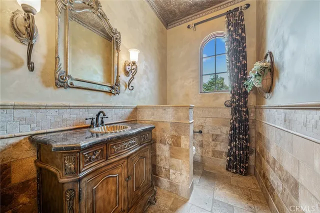 a bathroom with a granite countertop toilet sink and mirror