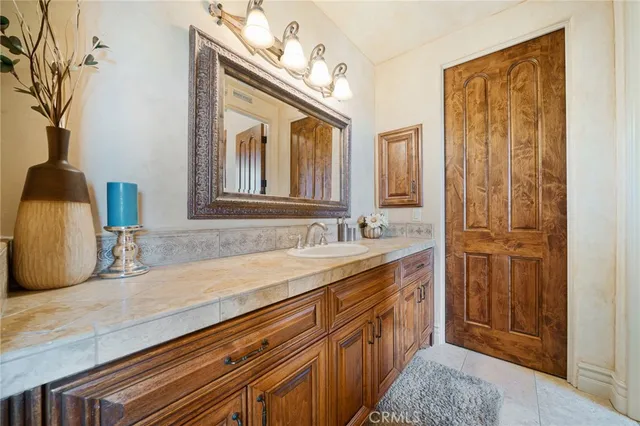 a spacious bathroom with a granite countertop toilet a sink and a mirror