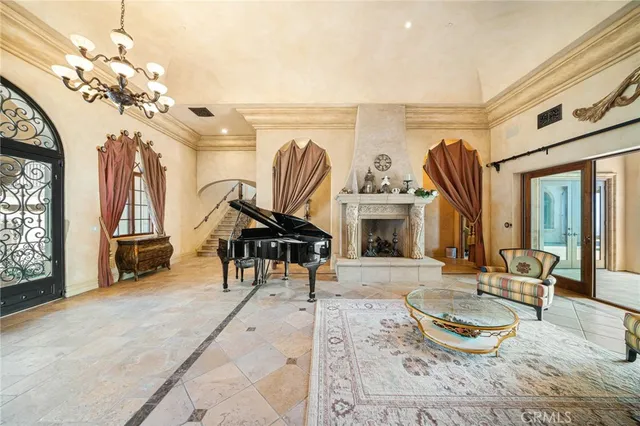 a living room with furniture a fireplace and a chandelier