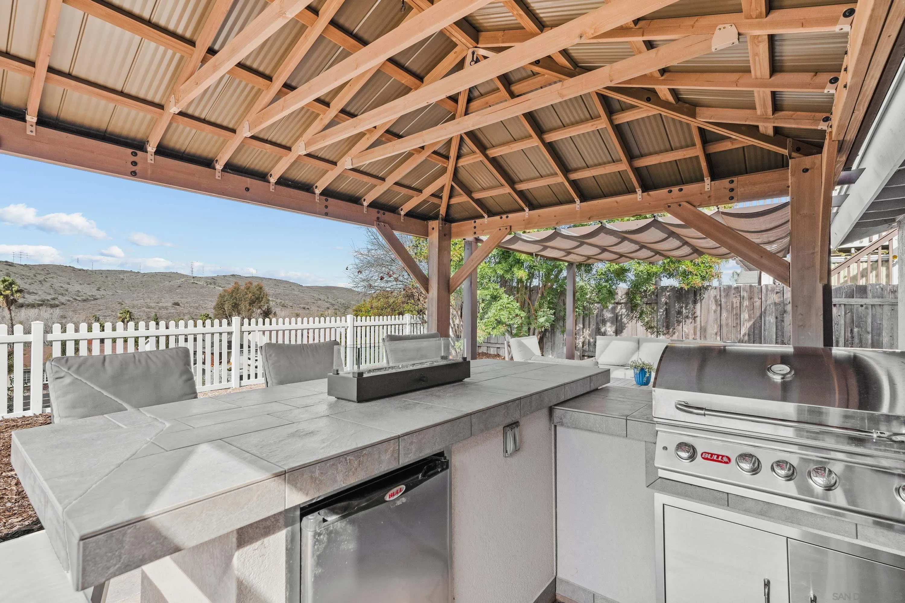 10472 Cadwell Road Santee, CA 92071 - Photo 18 of 30 a view of a roof deck with table and chairs a barbeque with wooden floor and fence
