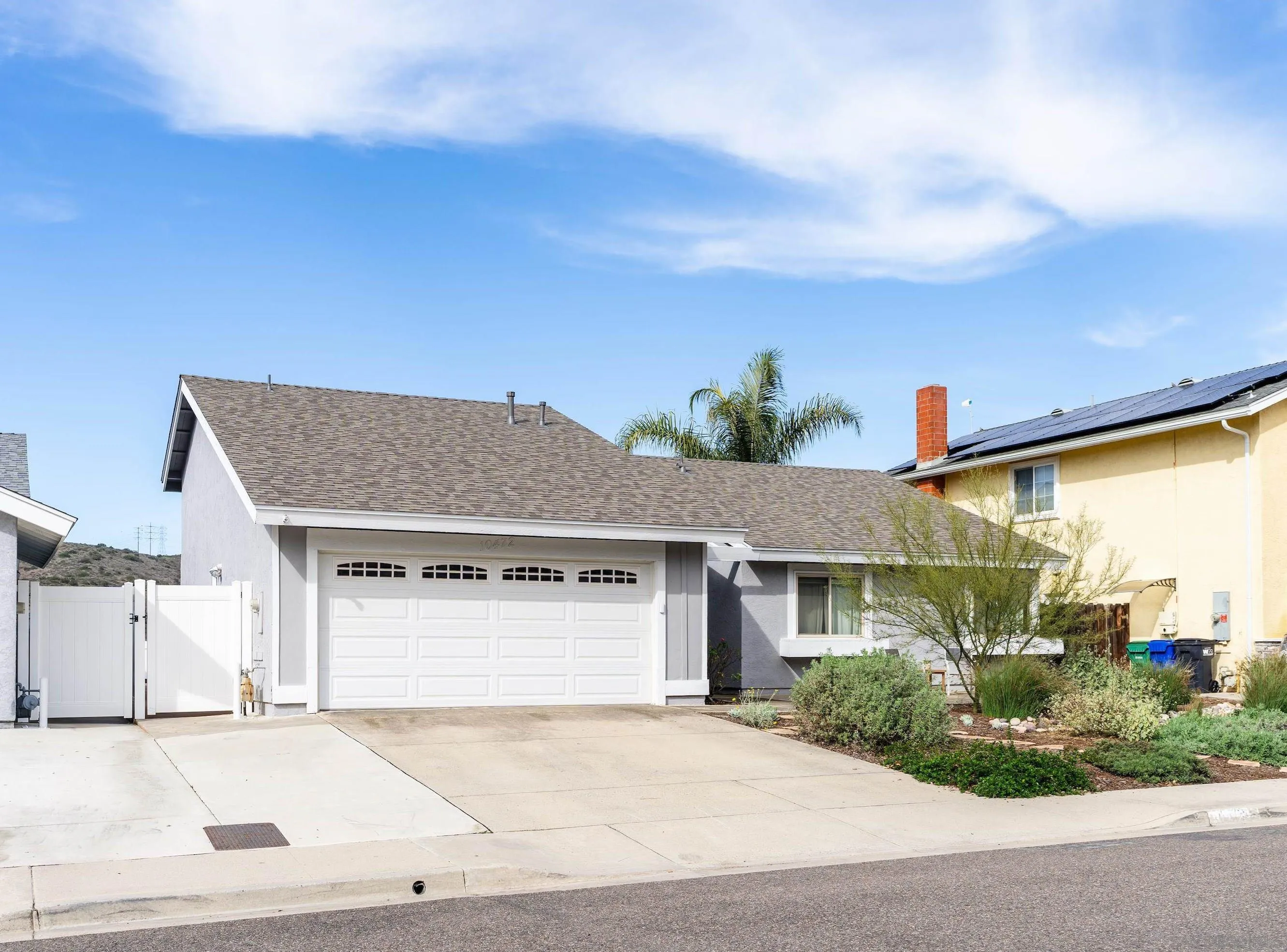 10472 Cadwell Road Santee, CA 92071 - Photo 3 of 30 a view of a white house next to a yard with road and plants