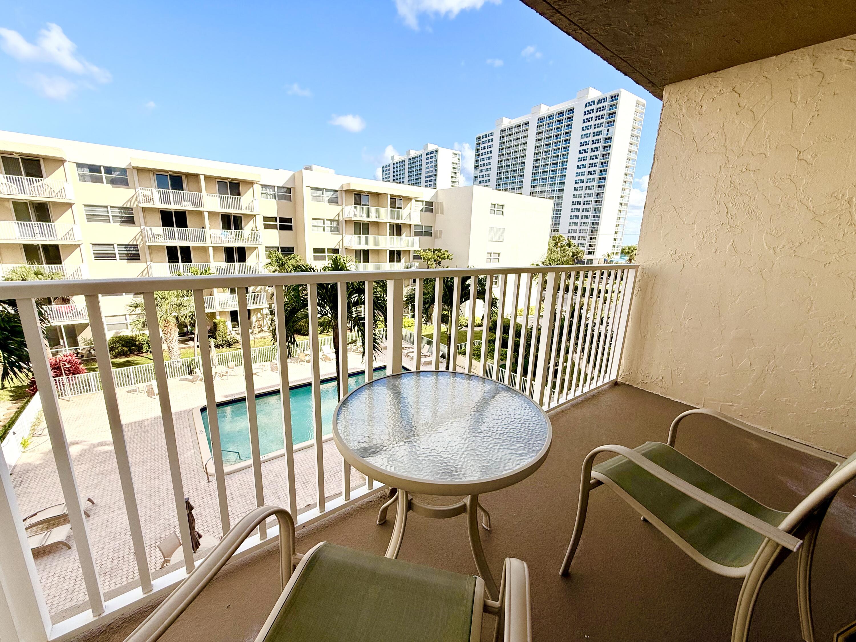 2929 South Ocean Boulevard, Unit 406 Boca Raton, FL 33432 - Photo 15 of 16 a balcony with table and chairs