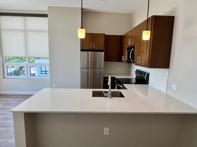 a kitchen with a sink a counter top space and stainless steel appliances
