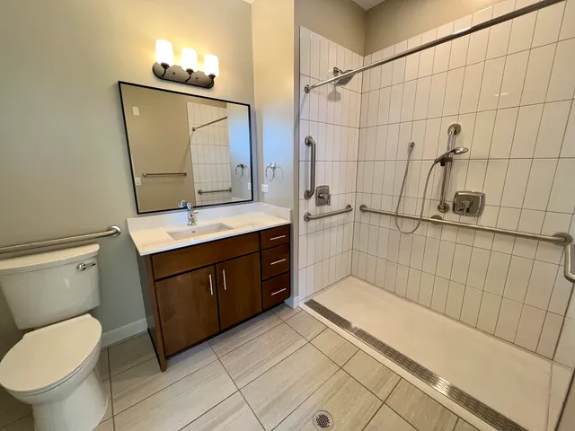 a bathroom with a granite countertop sink toilet and shower