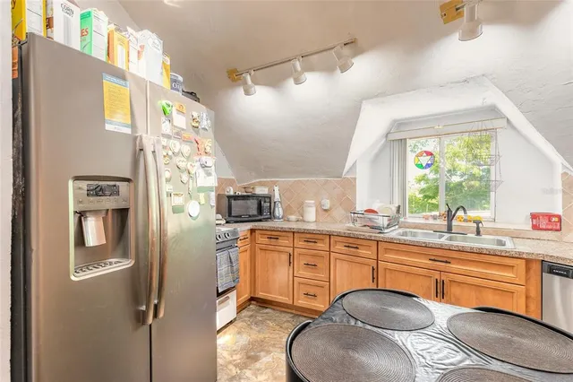 a kitchen with stainless steel appliances granite countertop a sink a stove and refrigerator
