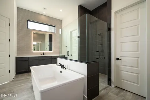 a spacious bathroom with a tub double sink and mirror