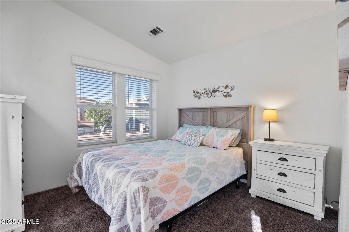 8865 East Baseline Road, Unit 1232 Mesa, AZ 85209 - Photo 17 of 38 a bedroom with a bed a lamp and a window