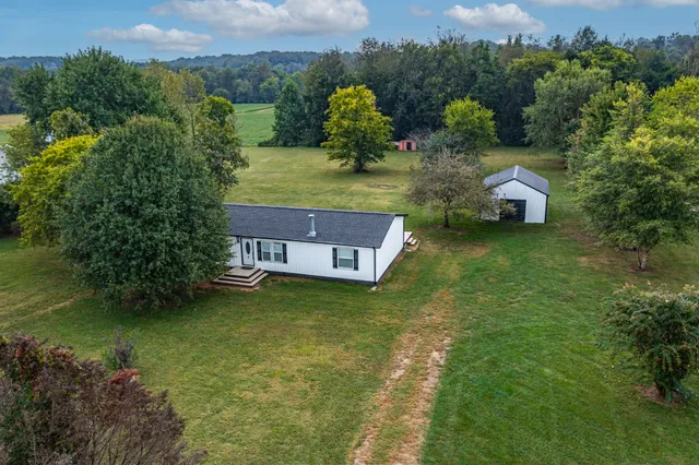 an aerial view of a house with garden space and a lake view