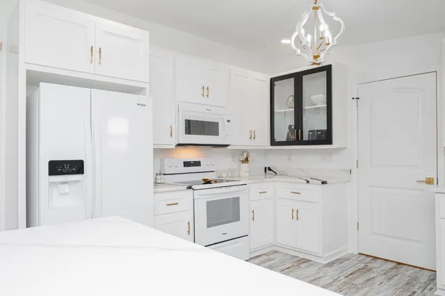 a kitchen with stainless steel appliances a white stove top oven and cabinets