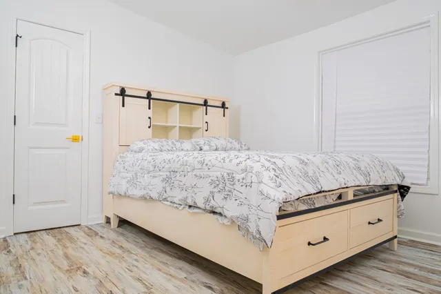 a living room with a dresser and a wooden floor