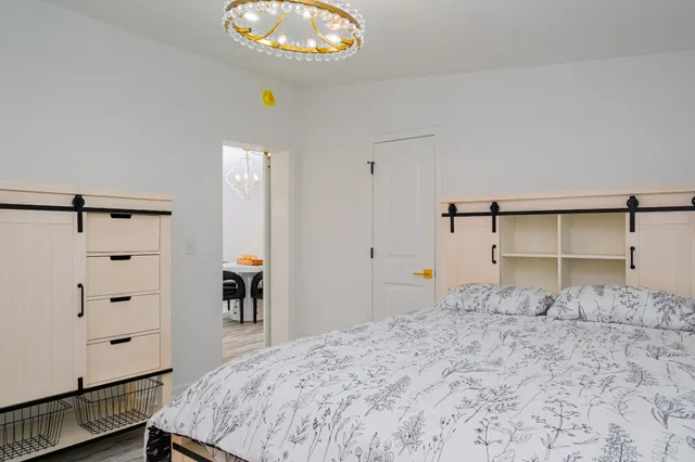 a bedroom with a bed and a chandelier