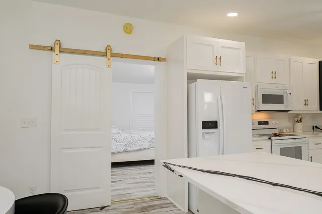 a kitchen with white cabinets and refrigerator